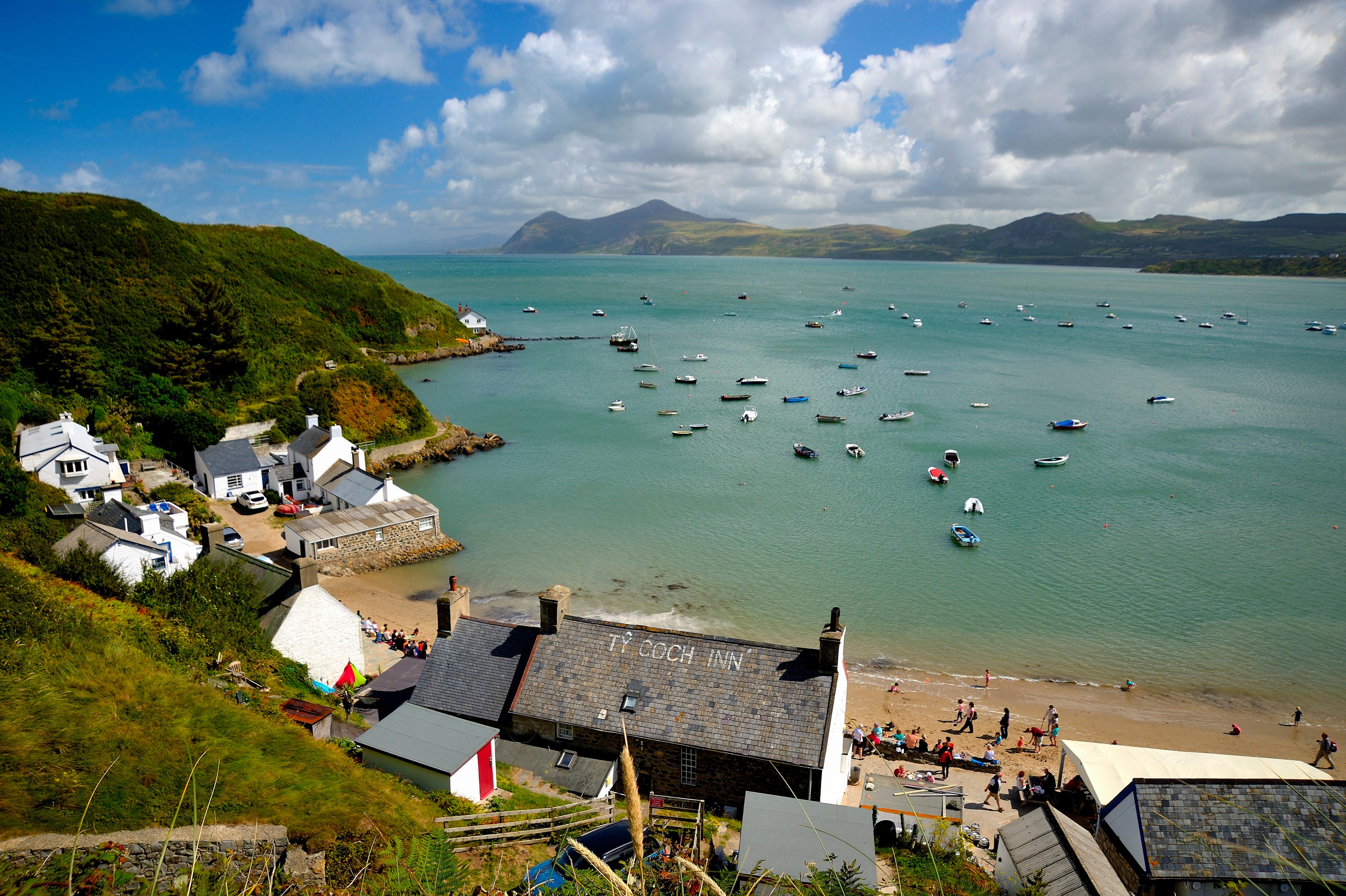 Aerial view of a small village on a bay with boats and a beach.
