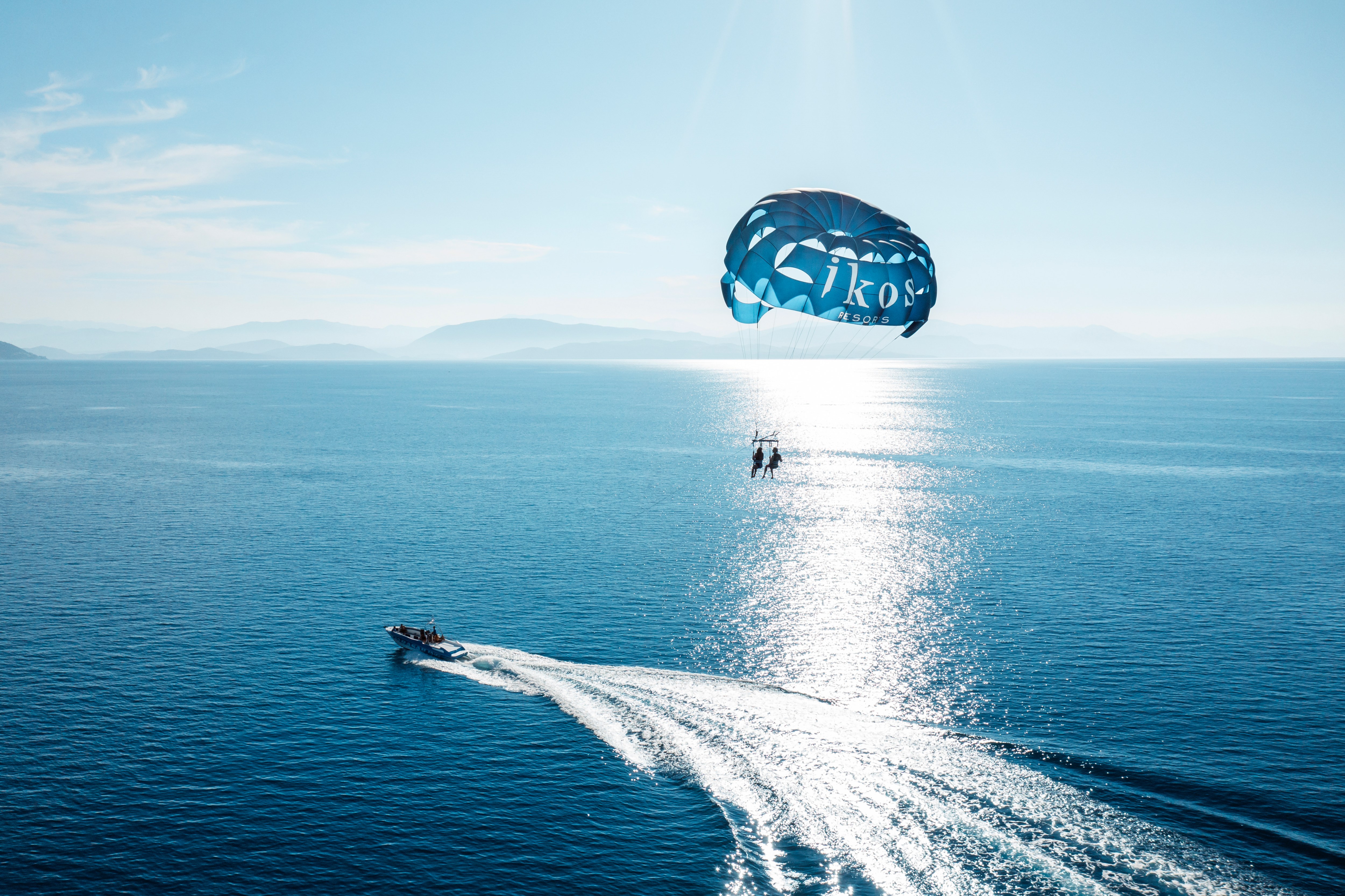 Two people parasailing off the coast near Ikos Dassia hotel in Corfu