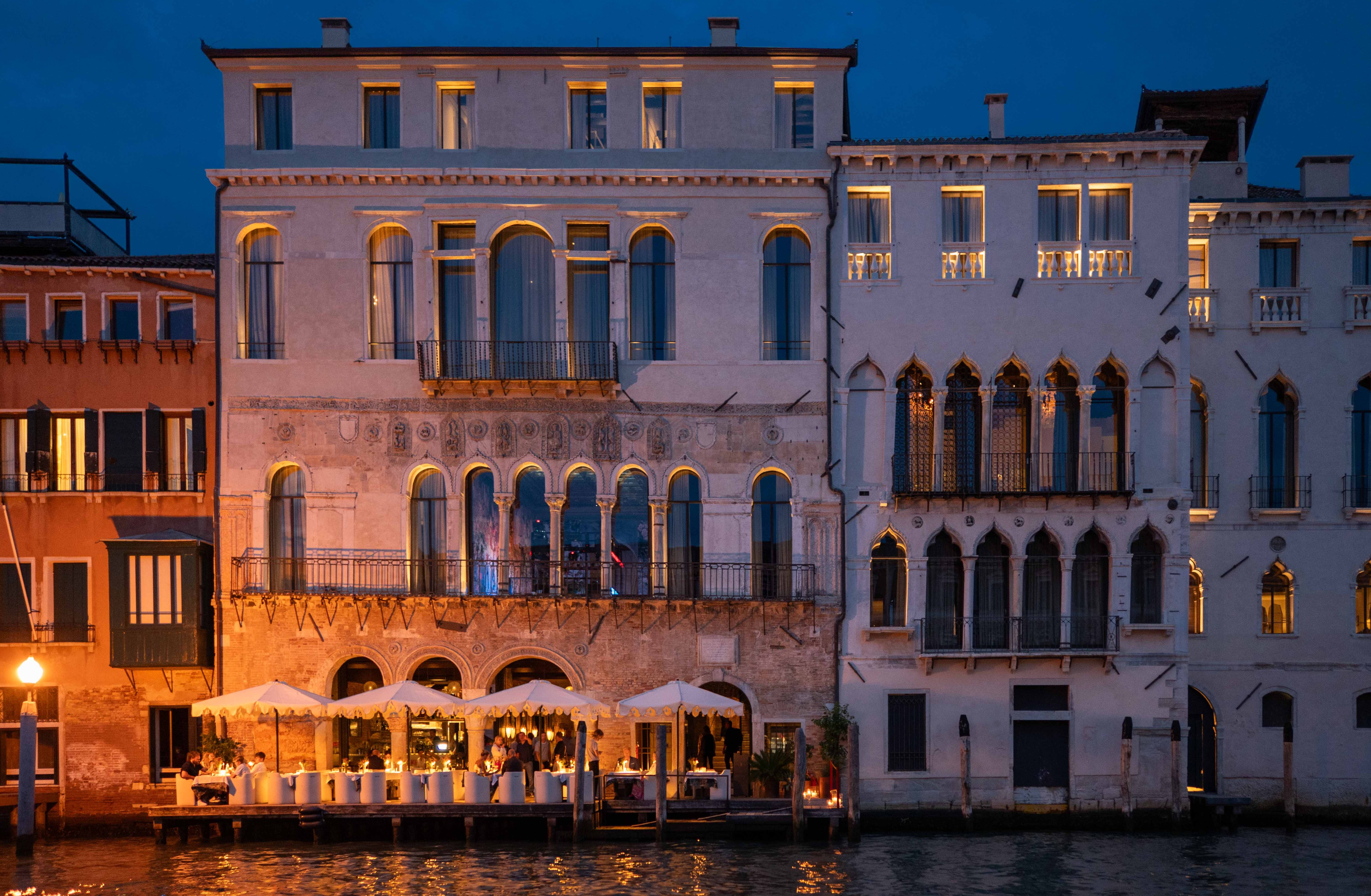 Venice Venice hotel at night with outdoor dining.
